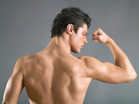 Rear view of man flexing biceps